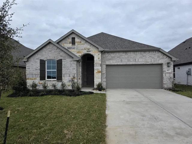 a front view of a house with a garden and plants