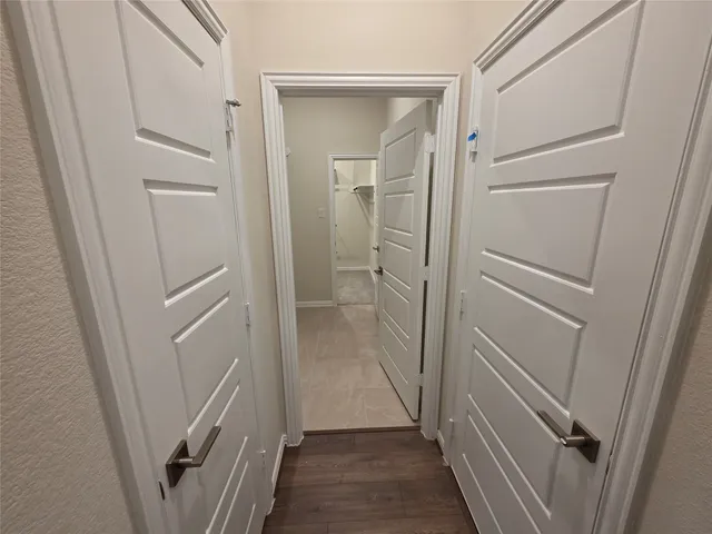 a view of an empty room with wooden floor and window