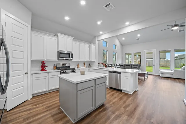 a kitchen with kitchen island white cabinets and refrigerator
