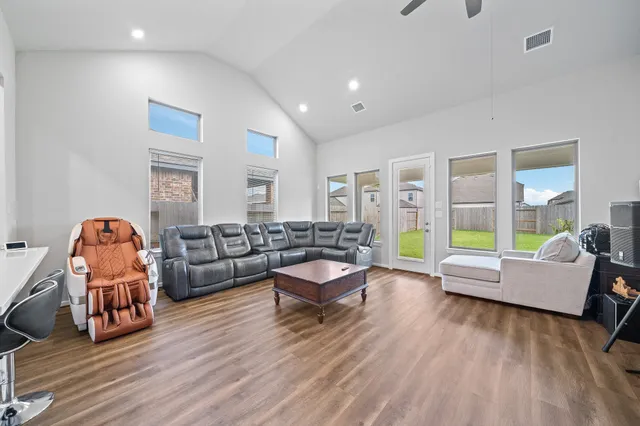 a living room with furniture kitchen view and a wooden floor