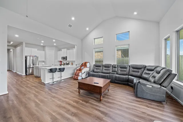 a living room with furniture and a wooden floor