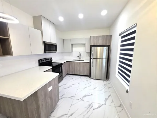a kitchen with stainless steel appliances a refrigerator sink and microwave