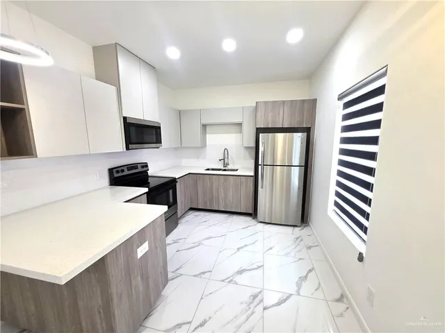 a kitchen with stainless steel appliances a refrigerator sink and microwave