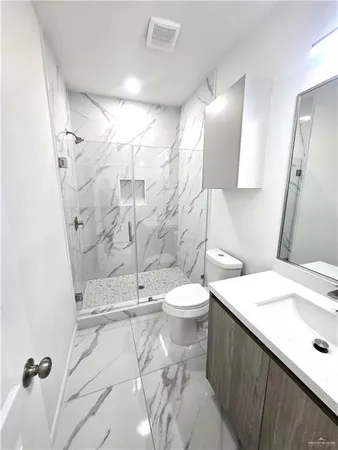 a bathroom with a sink a toilet and shower