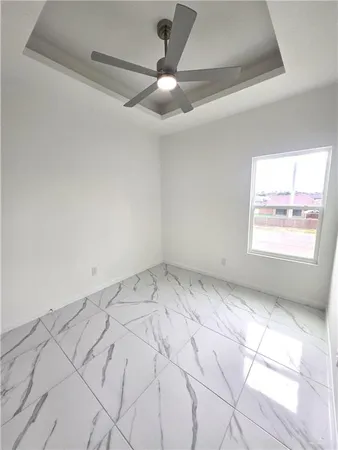 an empty room with windows and fan