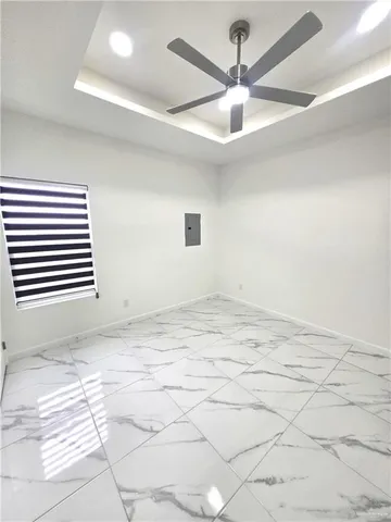 en empty room with windows and ceiling fan