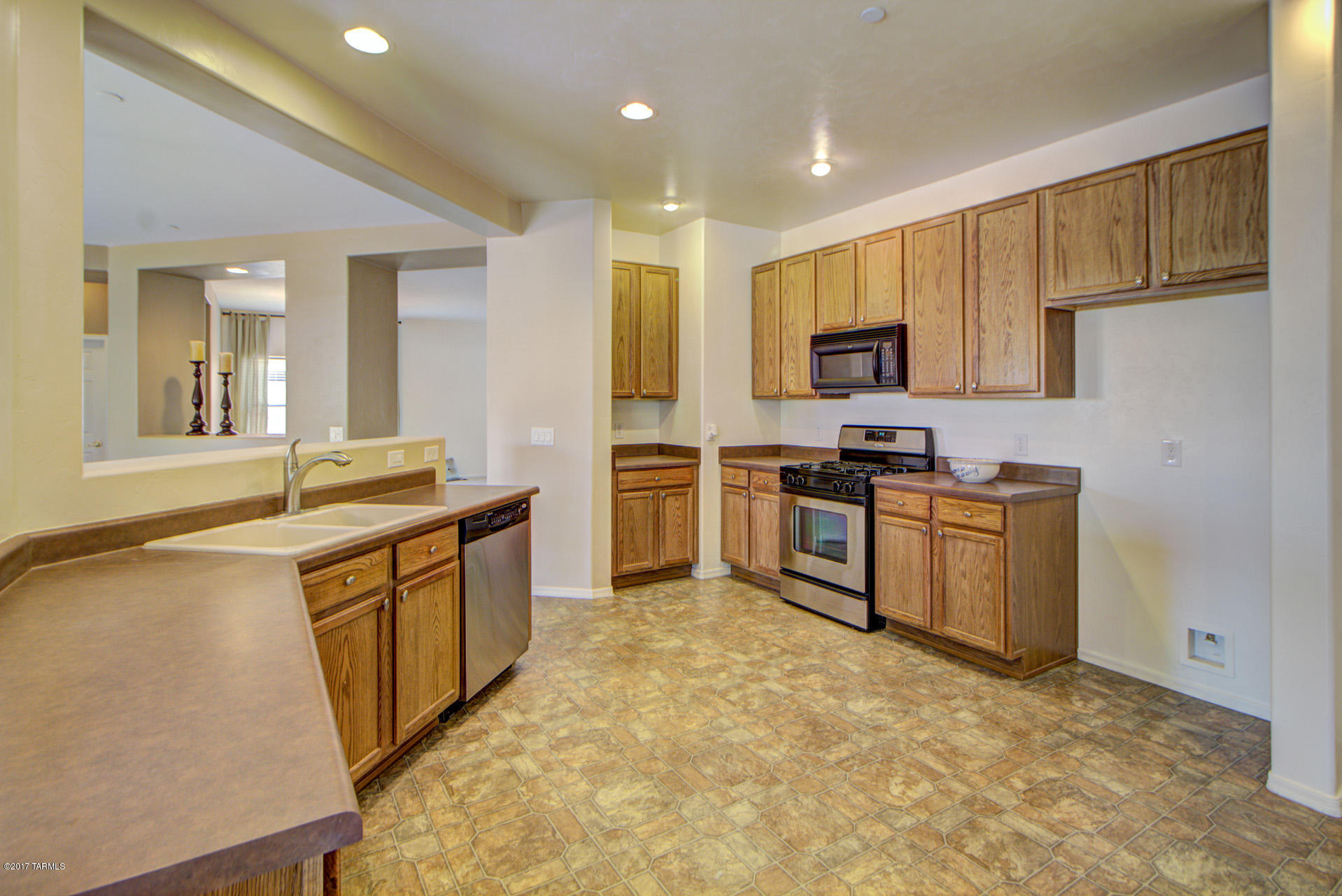 3588 East Mecate Road Tucson, AZ 85739 - Photo 10 of 36 a kitchen with stainless steel appliances granite countertop a stove top oven a sink dishwasher and a refrigerator with wooden floor