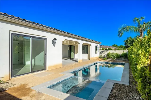 an empty room with floor to ceiling window and an entryway