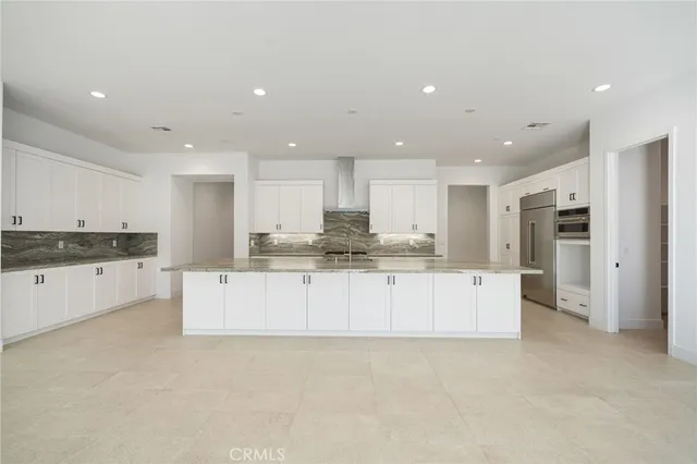a kitchen with stainless steel appliances granite countertop a sink and a white cabinets