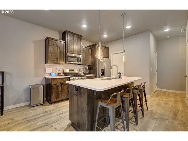a kitchen with kitchen island a sink stove and refrigerator