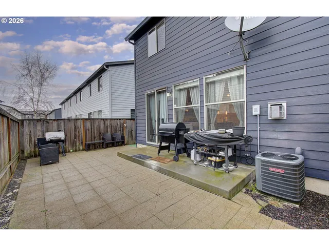 a backyard of a house with barbeque oven table and chairs