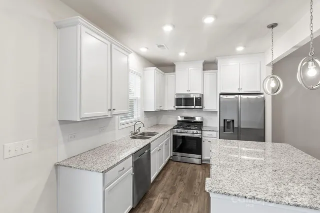 a kitchen with stainless steel appliances and white cabinets
