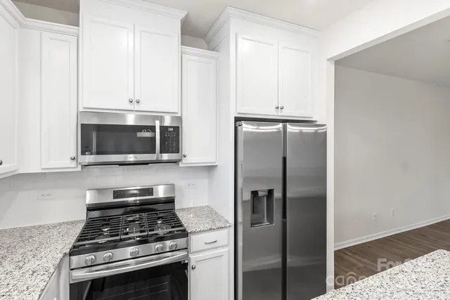 a kitchen with granite countertop white cabinets and a window