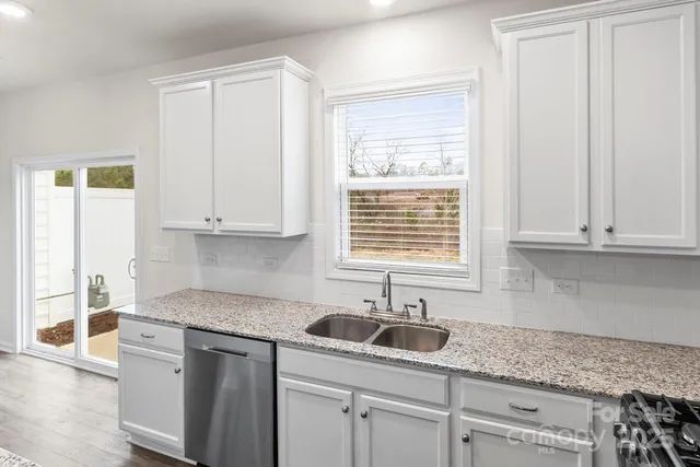a kitchen with kitchen island granite countertop cabinets and stainless steel appliances