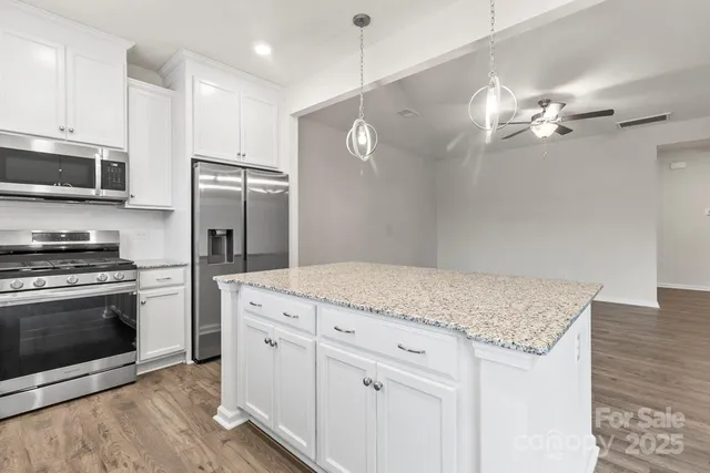 a kitchen with a sink cabinets and wooden floor