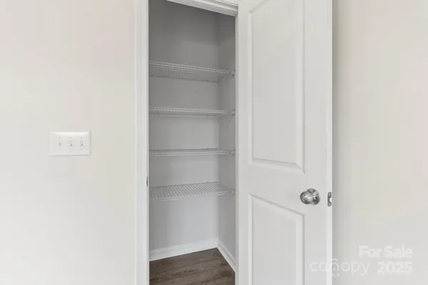 an empty room with wooden floor and a ceiling fan