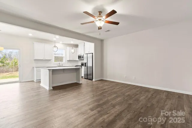 a kitchen with stainless steel appliances granite countertop a sink a refrigerator and a granite counter tops