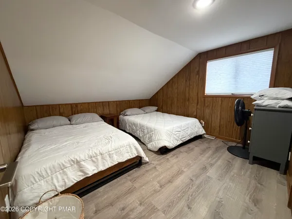 a bedroom with two beds and a flat screen tv