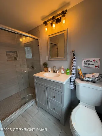 a bathroom with a sink a toilet and shower