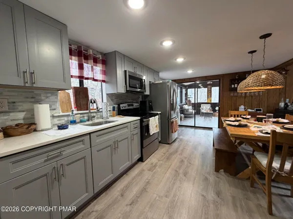 a kitchen with kitchen island granite countertop a sink appliances and cabinets