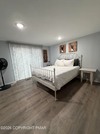 a spacious bedroom with a bed table and a window