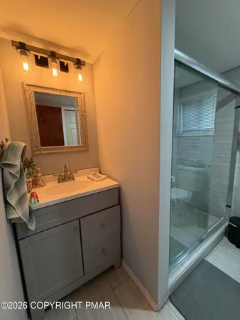 a bathroom with a sink a toilet and shower