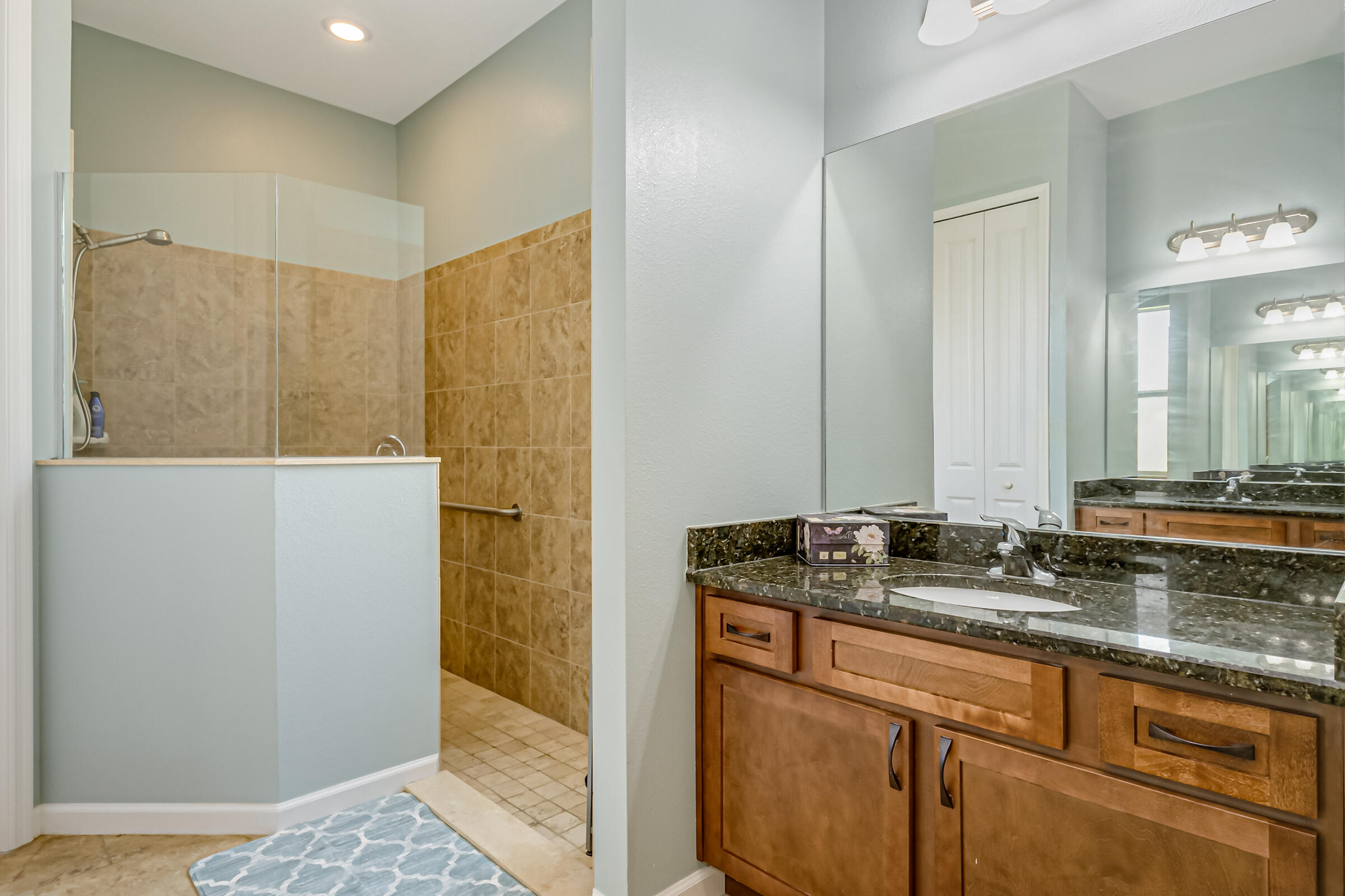 503 Heming Way Melbourne, FL 32901 - Photo 17 of 33 a bathroom with a granite countertop sink a mirror and shower