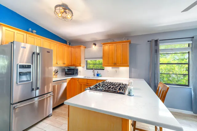 a very nice looking dining room with a large window a table and chairs