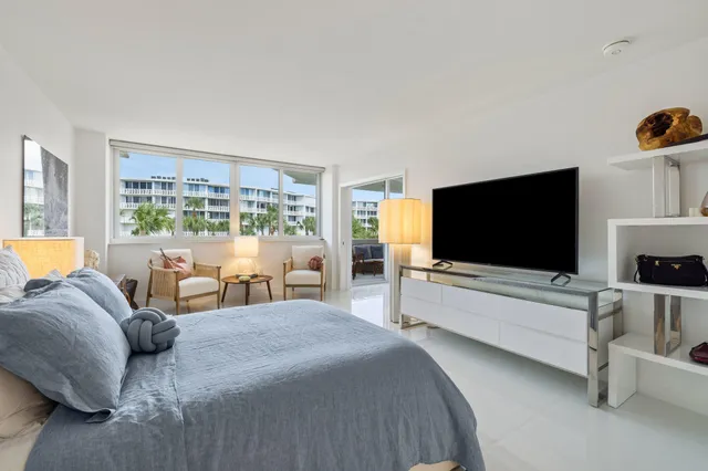 a view of a patio with table and chairs potted plants and palm tree