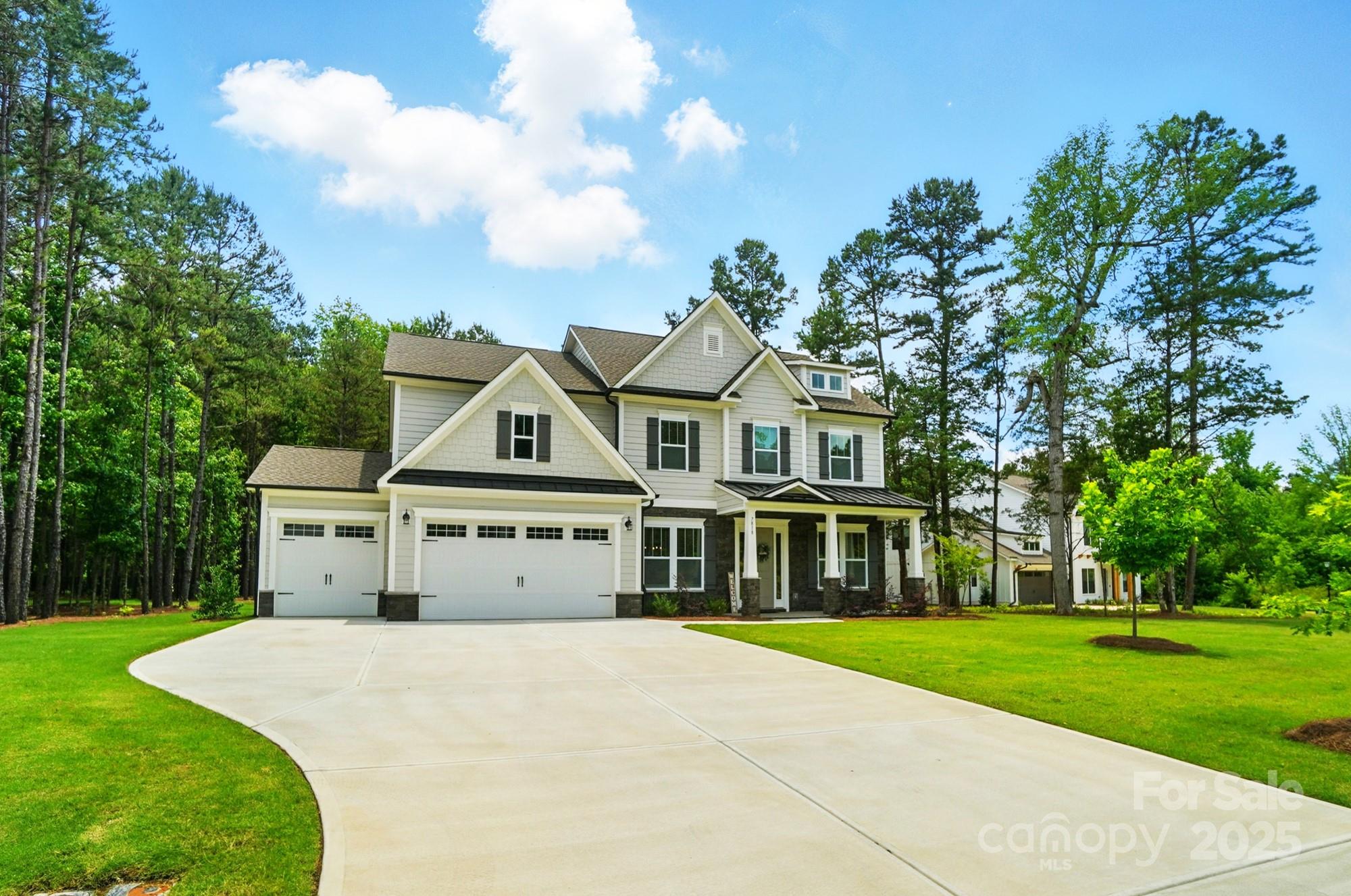 7818 Russell Road Indian Trail, NC 28079 - Photo 2 of 42 a view of a white house with a big yard and large trees