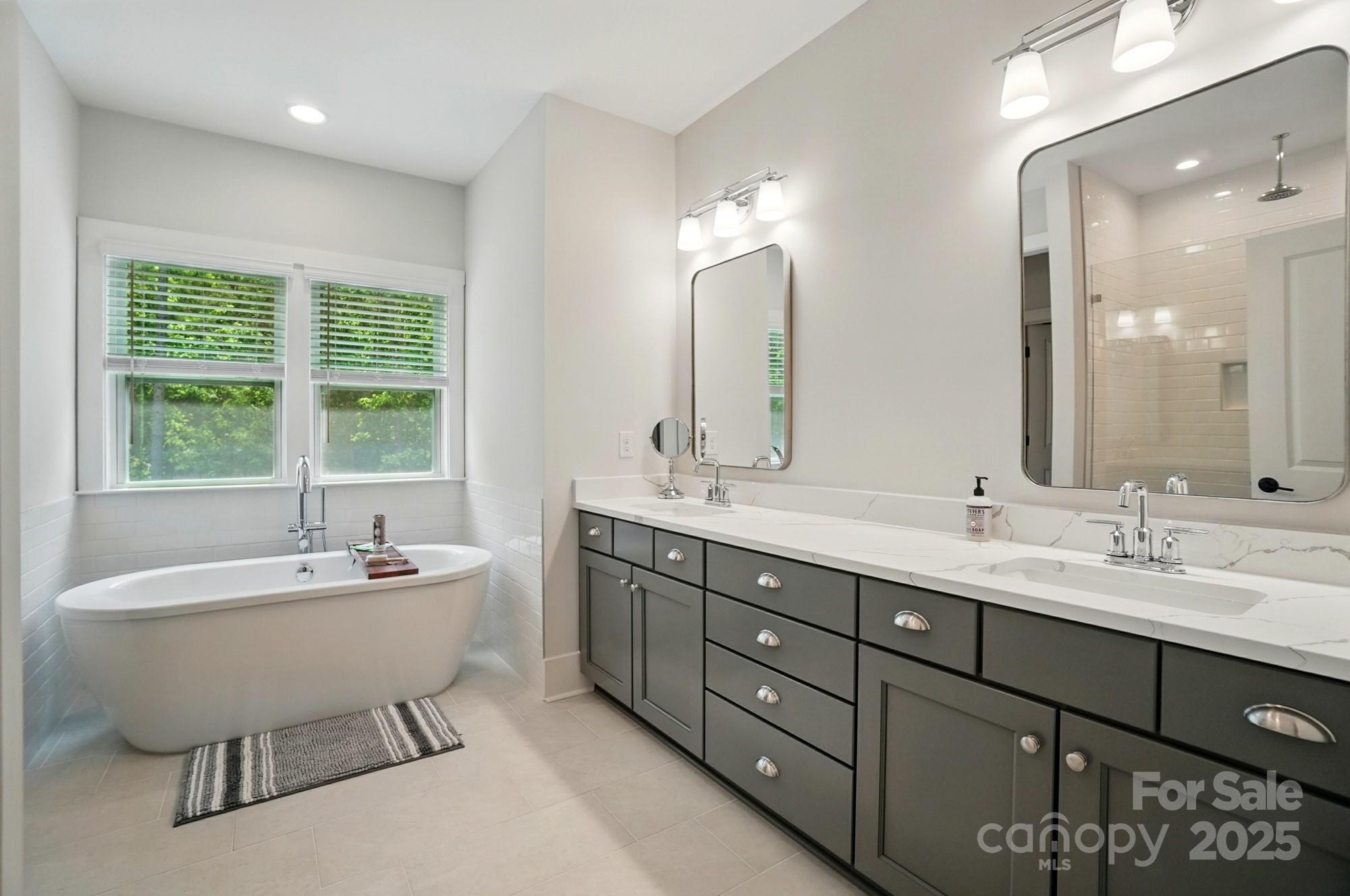 7818 Russell Road Indian Trail, NC 28079 - Photo 25 of 42 a bathroom with a double vanity sink bathtub and next to a window