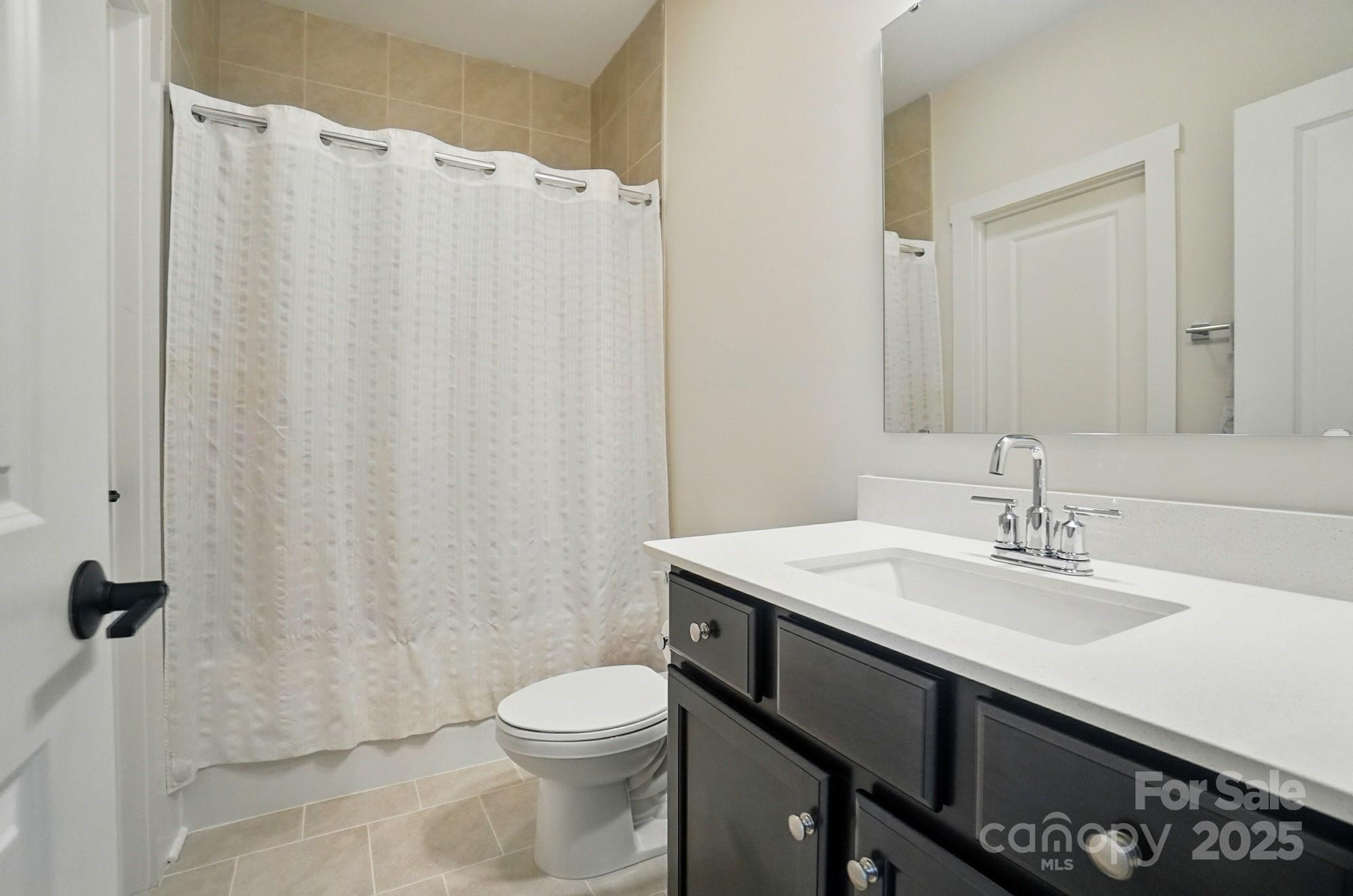 7818 Russell Road Indian Trail, NC 28079 - Photo 35 of 42 a bathroom with a sink a toilet and a mirror