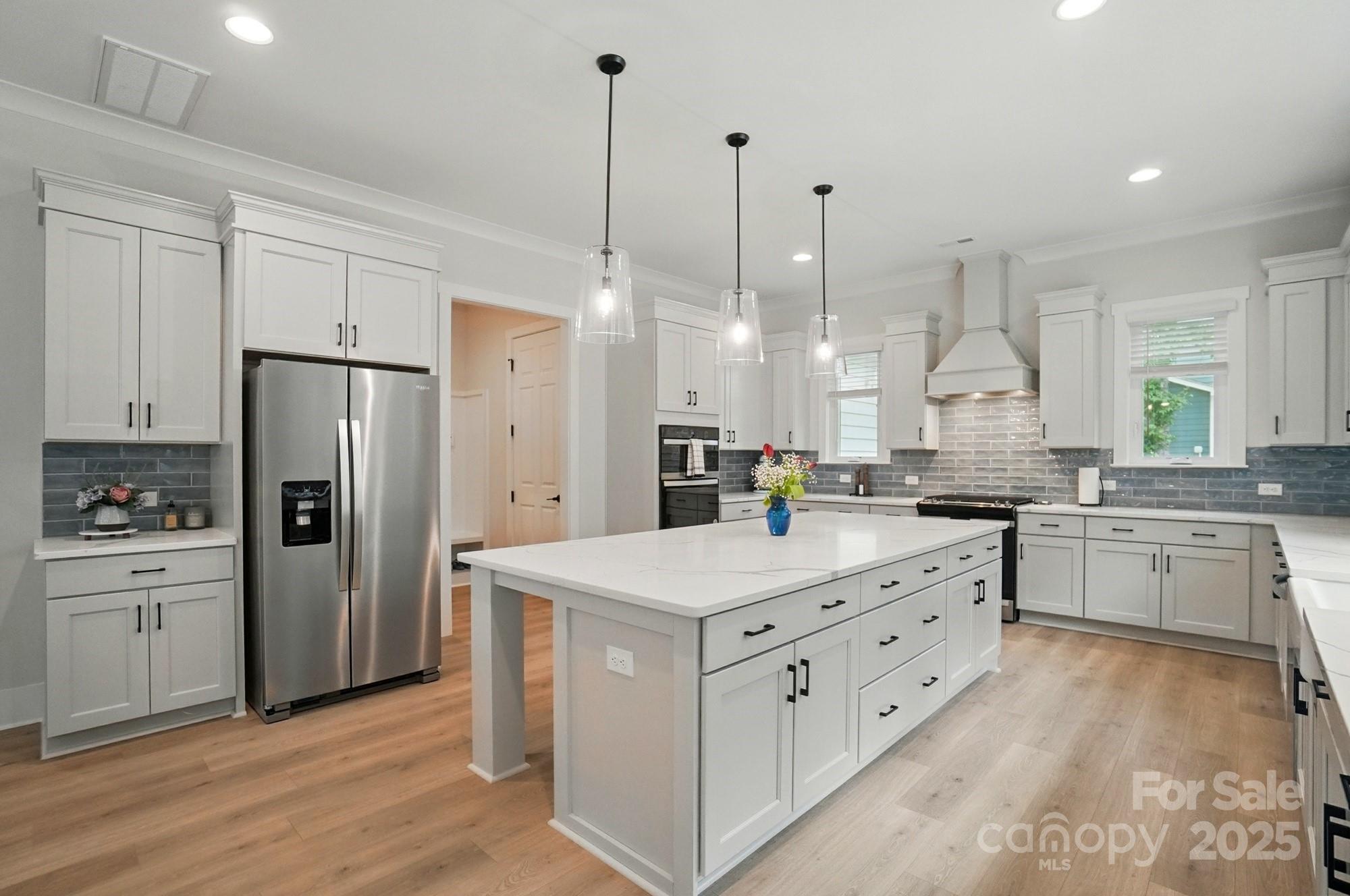 7818 Russell Road Indian Trail, NC 28079 - Photo 8 of 42 a kitchen with kitchen island white cabinets and refrigerator