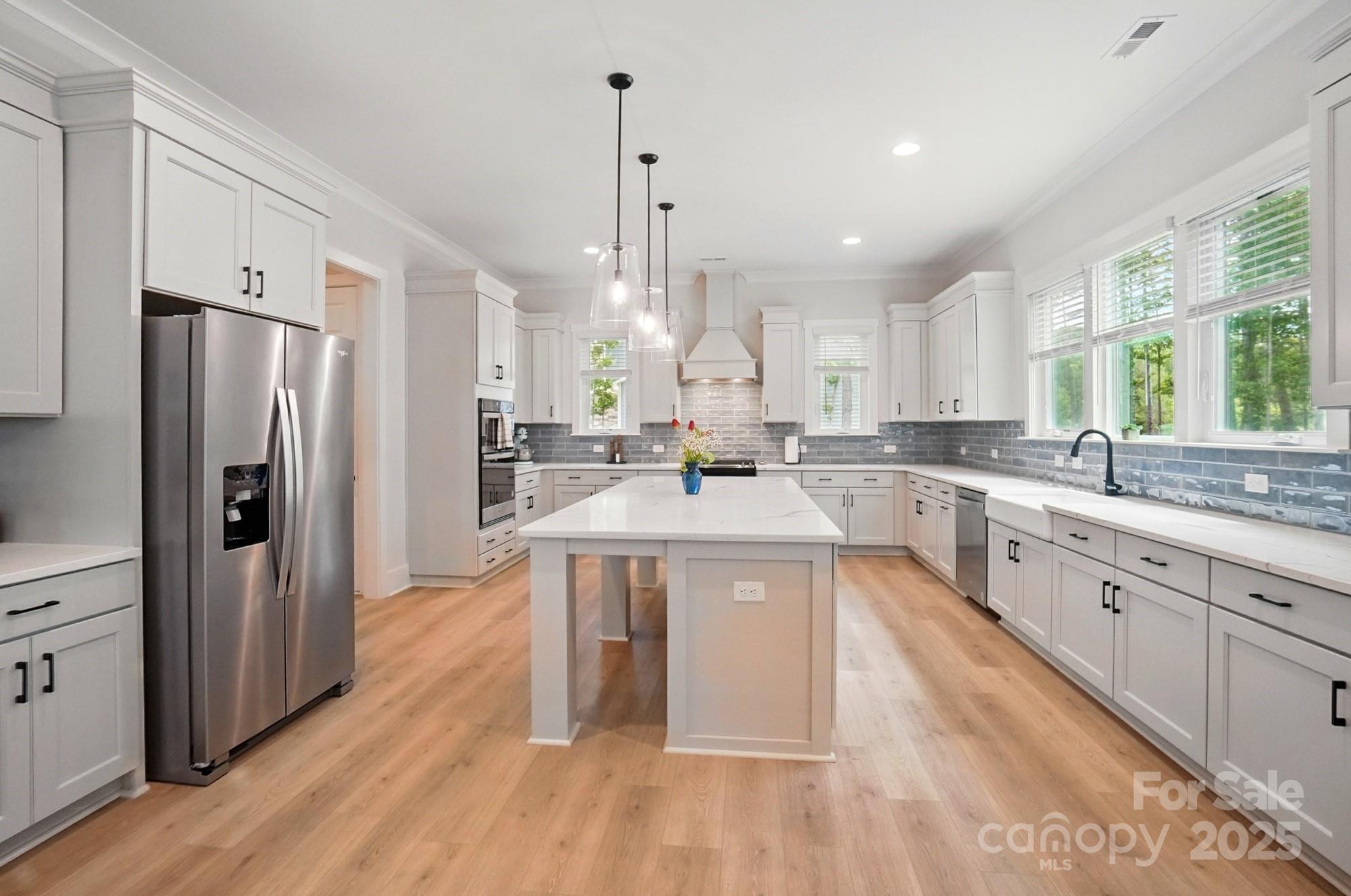 7818 Russell Road Indian Trail, NC 28079 - Photo 9 of 42 a large kitchen with stainless steel appliances granite countertop a sink a stove a refrigerator and island with wooden floor