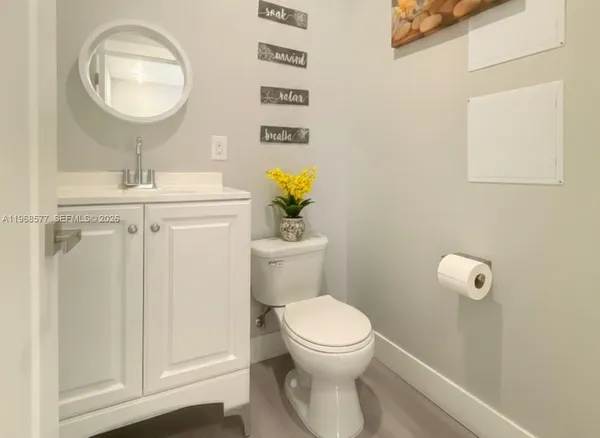 a bathroom with a toilet a sink and mirror