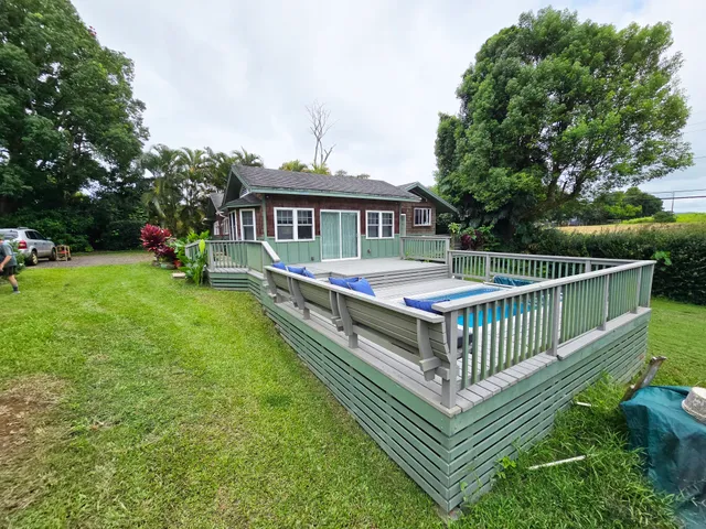 a view of a house with a wooden deck and a yard