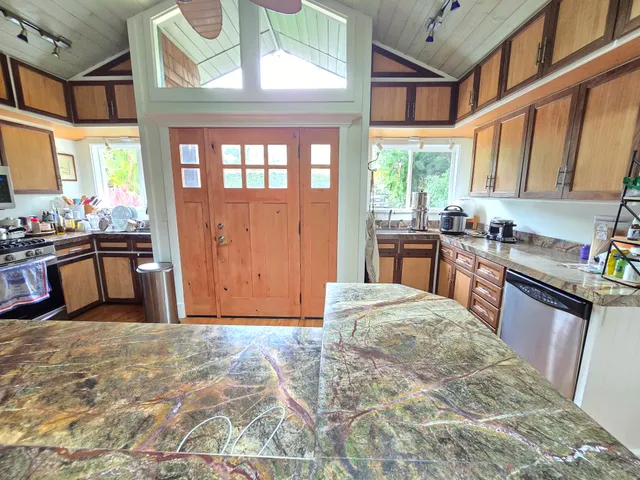 a kitchen with stainless steel appliances granite countertop a stove a sink and a refrigerator