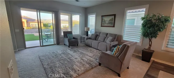 a living room with furniture and a floor to ceiling window