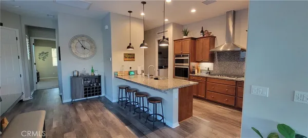a kitchen with stainless steel appliances granite countertop a refrigerator a stove and a wooden floors
