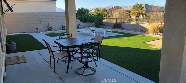 a backyard of a house with table and chairs