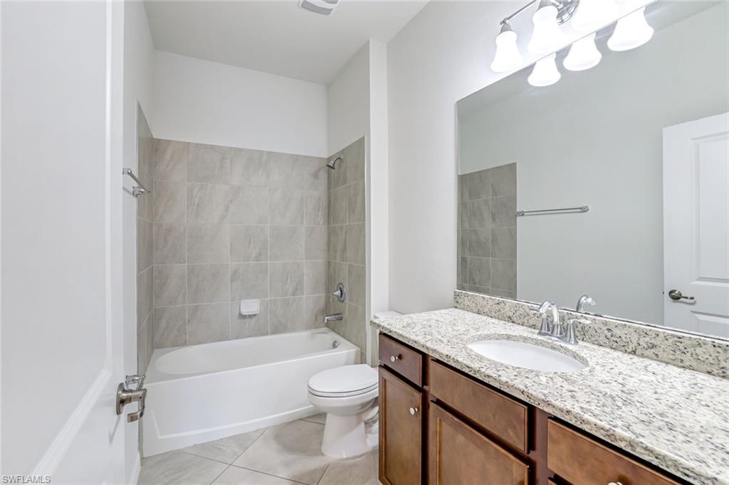 1750 Alameda Drive Naples, FL 34120 - Photo 14 of 39 a bathroom with a granite countertop sink a toilet and bathtub