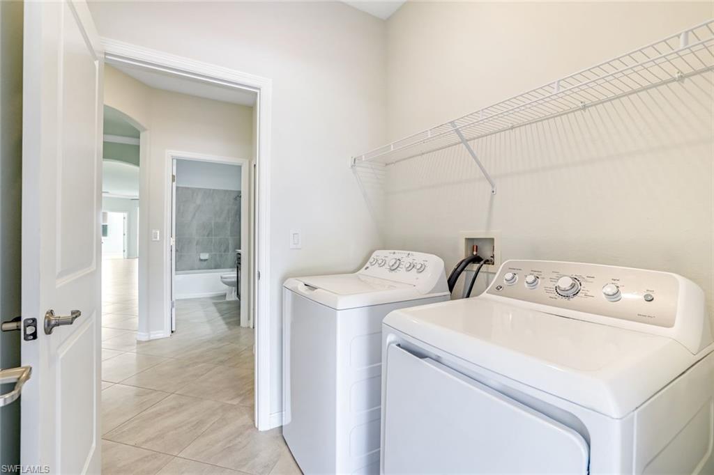 1750 Alameda Drive Naples, FL 34120 - Photo 16 of 39 a view of washer and dryer with bathroom in the background