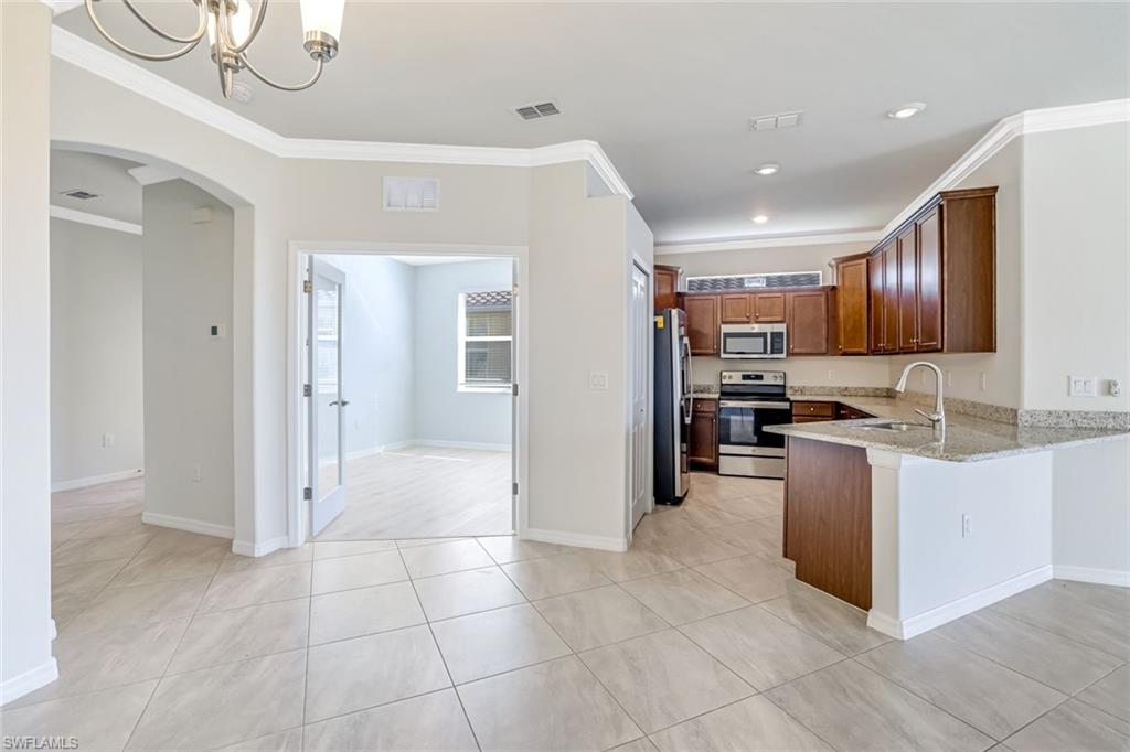 1750 Alameda Drive Naples, FL 34120 - Photo 6 of 39 a kitchen with stainless steel appliances granite countertop a refrigerator and a sink