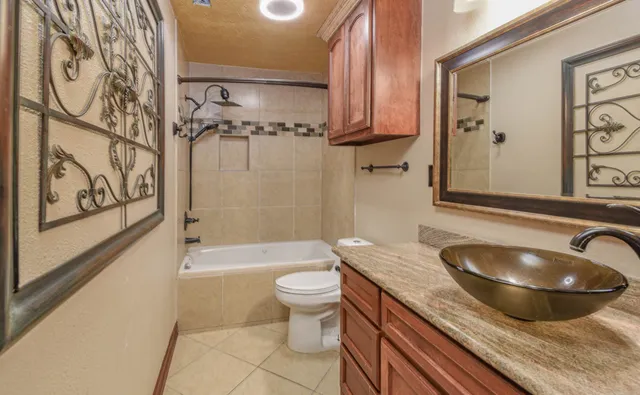 a bathroom with a granite countertop sink toilet and shower