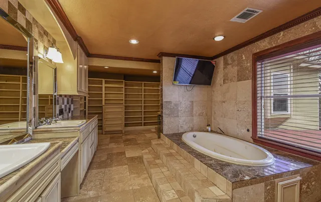 a bathroom with a granite countertop bathtub shower and vanity