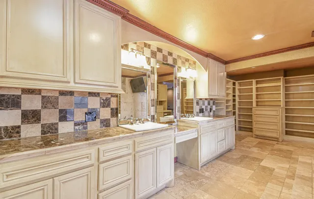 a bathroom with a granite countertop double vanity sink and a mirror