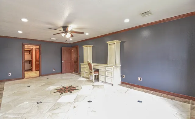 en empty room with windows and ceiling fan