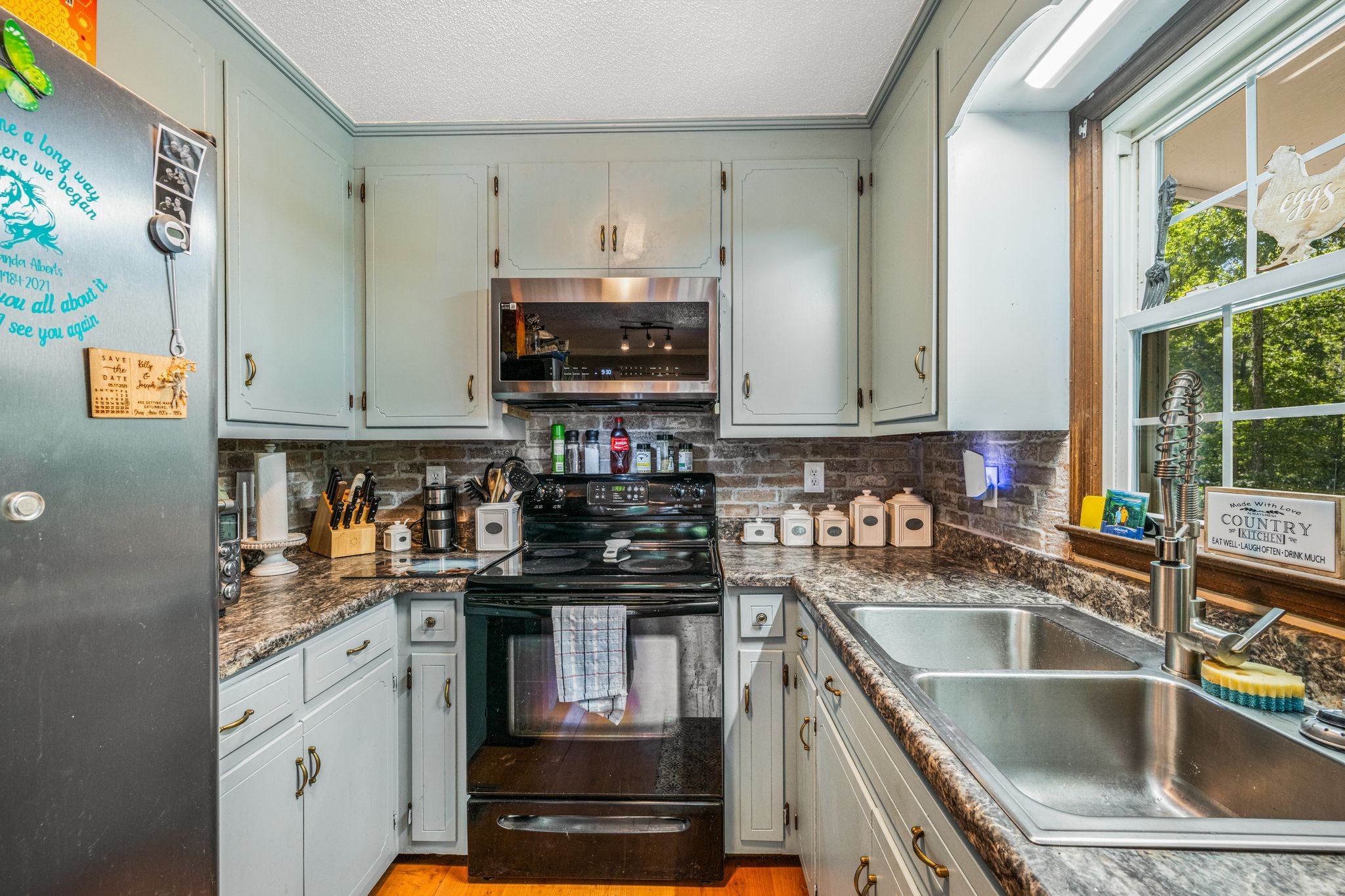 5835 Dog Creek Road Primm Springs, TN 38476 - Photo 6 of 37 a kitchen with granite countertop a sink a stove and cabinets