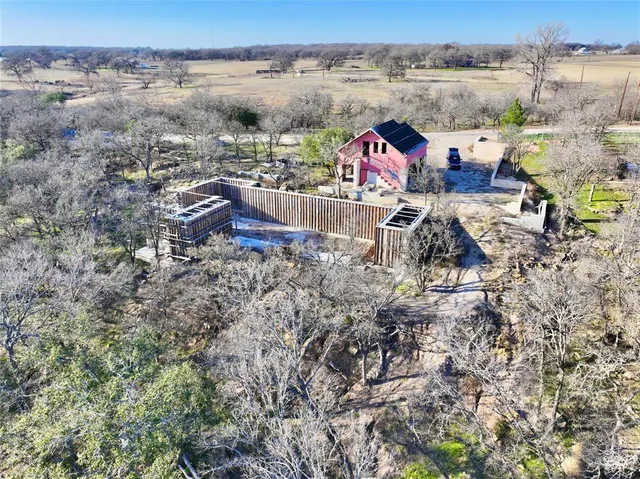 an aerial view of a house with large trees