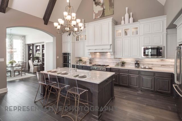 a kitchen with stainless steel appliances granite countertop a dining table chairs and granite counter tops